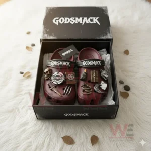 Dark red Crocs with Godsmack logo straps and metal style decorations displayed flat in their box surrounded by scattered leaves and coins on a white rug!