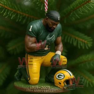 A decorative ornament of a Green Bay Packers player kneeling in reflection hanging on a Christmas tree representing tribute and pride for the team’s 106th anniversary.