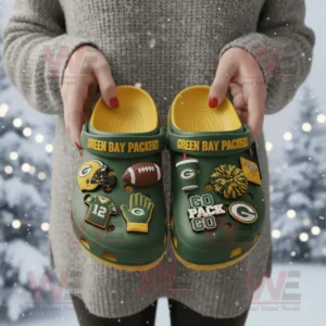 Person holding Green Bay Packers themed Crocs adorned with team symbols and cheer charms in a snowy landscape!
