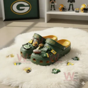 Green and yellow Green Bay Packers clogs with football charms displayed on a white furry rug in a team themed room!