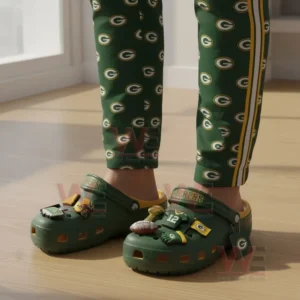 Person wearing green and yellow Green Bay Packers clogs with football charms standing indoors!