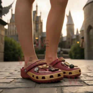 Griffindor Premium Crocs Crocband Clogs With Charms 4 Red and gold clogs with themed decorations worn on cobblestones with castle structures behind.