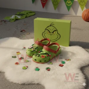 Green Grinch themed clogs with holiday charms displayed on a white furry rug in front of a themed box!