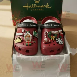 Red Hallmark Channel Crocs with festive Christmas decorations arranged in box against green branded background!