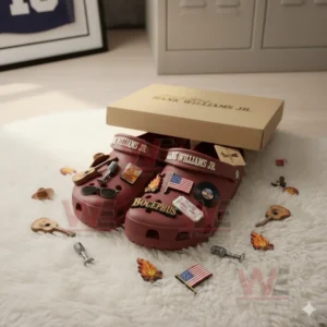 Red clogs partly inside a box with multiple country themed charms around them on a rug.