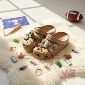 Brown clogs decorated with farm themed charms resting on a fluffy white surface surrounded by miniature rustic items!