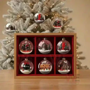 A collection of ACDC themed Christmas ornaments displayed in a wooden case in front of a lit Christmas tree.