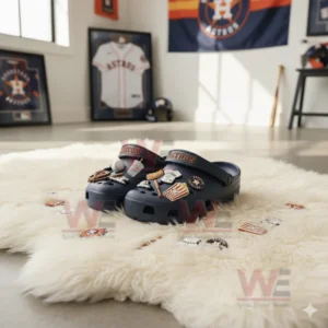 Dark blue clogs with baseball themed charms on a white fluffy rug in a sports room.