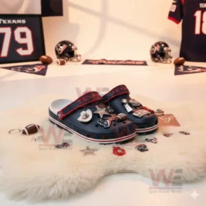 Dark blue clogs with football themed charms on a white fluffy rug in a team themed room.