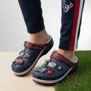 Houston Texans Crocs Crocband Clogs With Charms 8 Person wearing dark blue football themed clogs standing on artificial grass.