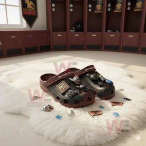 Black and maroon clogs with dragon themed charms on a white rug in a locker room.