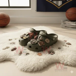 Green clogs with artistic nature themed charms on a white fluffy rug.