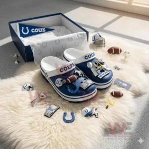 Blue and white clogs with football themed charms on a white fluffy rug near an open box.