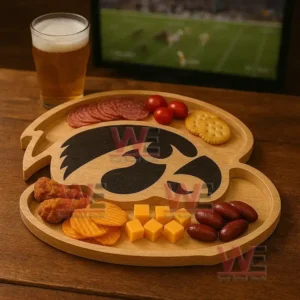 A bird shaped wooden snack tray filled with various foods sits beside a glass of beer with a sports game visible on a television in the background!