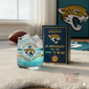 Jacksonville Jaguars 1995-2025 30th Anniversary Whiskey Glass 4 A clear view of a Jacksonville Jaguars anniversary glass with ice next to its themed box in a well lit room decorated with team colors!