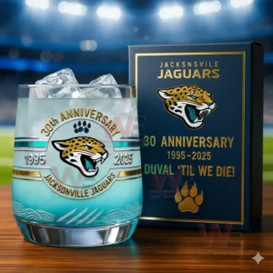Jacksonville Jaguars 1995-2025 30th Anniversary Whiskey Glass 5 A close up depiction of a Jacksonville Jaguars anniversary glass with ice positioned before a themed box with a brightly lit stadium in the background!
