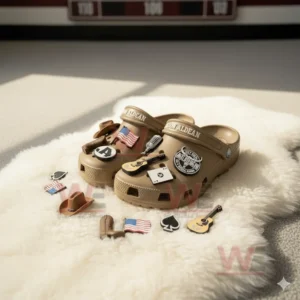 Brown clogs with country themed charms on a white fluffy rug in sunlight.