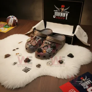 Alt text: Johnny Depp-themed Crocs with movie-inspired charms inside a box on a fluffy white rug.
