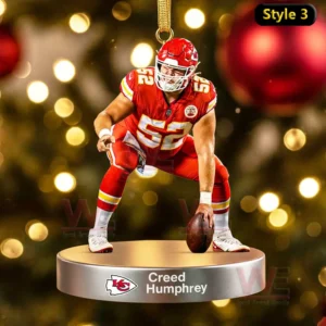 A football player ornament in a snap position on a round silver base before a Christmas tree!