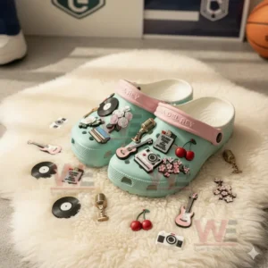 Pastel green clogs covered in assorted music and floral charms displayed on a white furry mat!