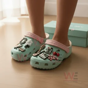 Lana Del Rey Crocs Crocband Clogs With Charms 8 Pastel green clogs decorated with assorted themed charms worn on feet on a wooden floor!