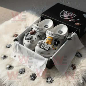Gray Las Vegas Raiders Crocs inside branded black box with sports charms and scattered team accessories on white fur rug!
