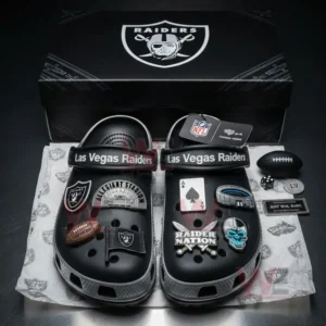 Las Vegas Raiders Crocs inside a box with football, stadium, and team-themed charms displayed around them.