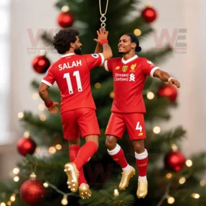 A Christmas ornament of two Liverpool football players giving a high five hanging on a tree decorated with red baubles and golden lights!