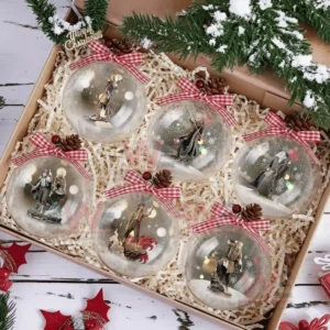 A gift box containing six clear Christmas ornaments showing heroic figures in snowy scenes.