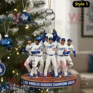 A holiday ornament of Los Angeles Dodgers players holding a trophy with a blue and white themed Christmas tree in the background.
