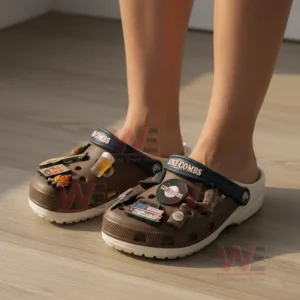Alt text: Person wearing Luke Combs-themed Crocs with country-inspired charms, standing on a floor.