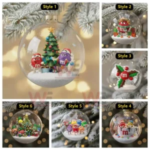 A round glass ornament displaying two M and M characters dressed for Christmas while decorating a tree in a snowy miniature scene!
