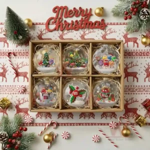 M&M'S Christmas Ornament 2025 9 A set of six M and M themed Christmas ornaments placed in a decorative gift box surrounded by festive holiday items!