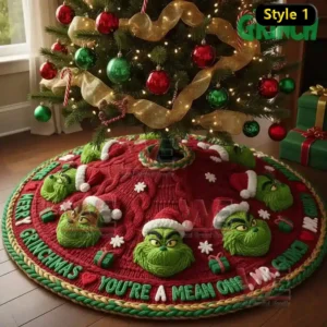 A red Grinch themed Christmas tree skirt with raised green faces and holiday decorations under a lit tree.
