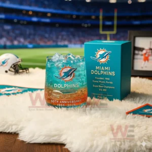 A close look at a teal Miami Dolphins anniversary glass with ice next to a themed box set against a brightly lit football field!