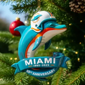 A Miami Dolphins sixtieth anniversary dolphin ornament hanging on a Christmas tree branch with lights behind it.