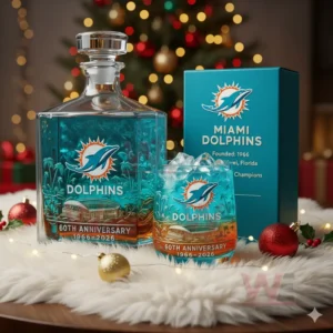 Alt text: A Miami Dolphins 60th Anniversary whiskey decanter and glass set displayed on a holiday table with a Christmas tree in the background.