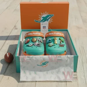 Miami Dolphins Crocs Crocband Clogs With Charms 9 Alt text: Miami Dolphins-themed Crocs with NFL-themed charms inside a box on a wooden surface.