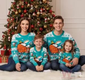 Alt text: Family of four wearing matching Miami Dolphins Snoopy Christmas sweaters in front of a decorated Christmas tree.