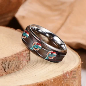 A shiny dark ring with dolphins symbols arranged evenly on a textured wood background!