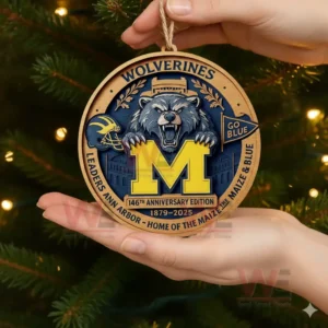 Hand holding Michigan Wolverines 146th Anniversary Edition Christmas ornament near decorated Christmas tree!