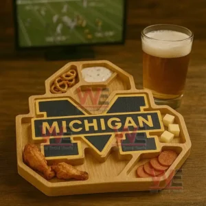A wooden tray with a central team design filled with snacks sits on a wooden table next to a glass of beer with a sports screen in the background!