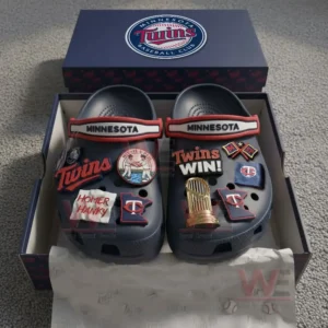 Navy blue Minnesota Twins clogs with multiple team themed charms arranged inside an open box.