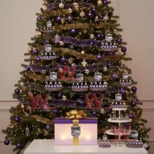 Alt text: A Minnesota Vikings-themed Christmas tree decorated with Purple People Eaters ornaments and memorabilia, with a gift box nearby.