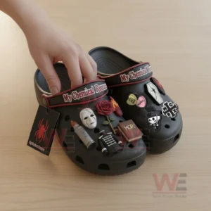 My Chemical Romance Crocs with Charms 6 Close up of My Chemical Romance Crocs with unique themed charms and a hand adjusting them on a light wooden surface!