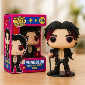 My Only Angel Yungblud Pop Vinyl Figures 5 Vinyl singer figure with black and red hair holding a microphone next to a colorful box on a wooden table. ``