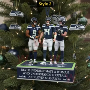 Three football players in blue uniforms stand on a decorative base as a christmas tree ornament surrounded by Seattle Seahawks themed decorations!