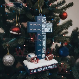 A blue cross shaped ornament with team symbols and small football items hangs on a Christmas tree decorated with red blue and silver ornaments!