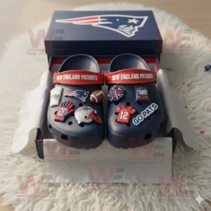 Navy blue New England Patriots Crocs with themed charms inside a team box on a white rug!