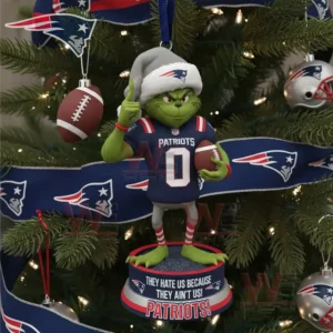 A green jersey wearing character ornament hangs on a Christmas tree decorated with blue team ribbons football ornaments and silver baubles!